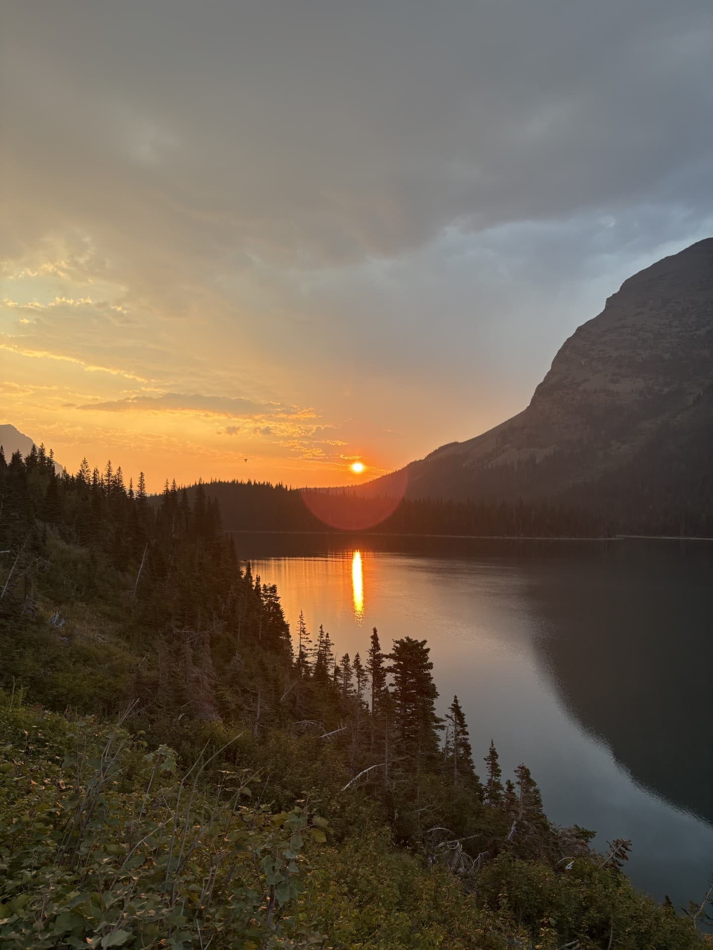 Sunset over a mountain lake, the sun reflected on the water
